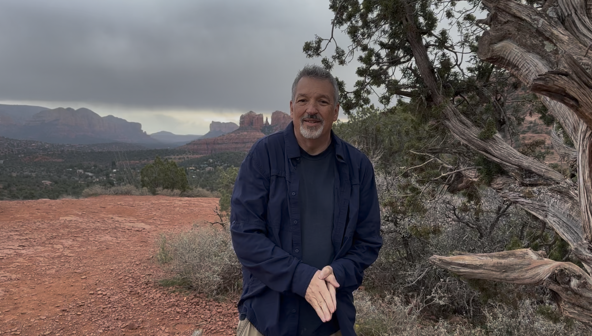 Rick Reynolds soul coach and hypnotherapist standing in Sedona Arizona with red rock formations behind him